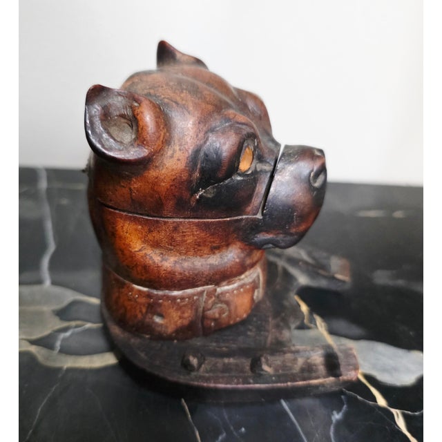 Victorian-era desk accessory, specifically a bulldog-shaped inkwell, crafted from carved wood with inset glass...