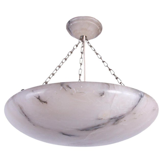 Antique carved Alabaster Art Deco ceiling light suspended on chains. The pendant spreads a fantastic ambient light. An...