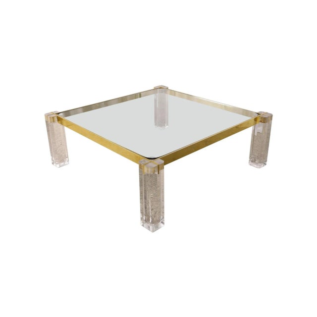 Vintage Mid-Century squared coffee table made in USA in the 1970s. Its standout feature lies in the transparent lucite...