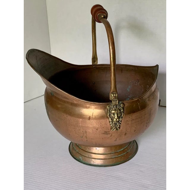 This antique copper coal scuttle was first created in England, circa 1880. Built of copper with an intricate brass and...