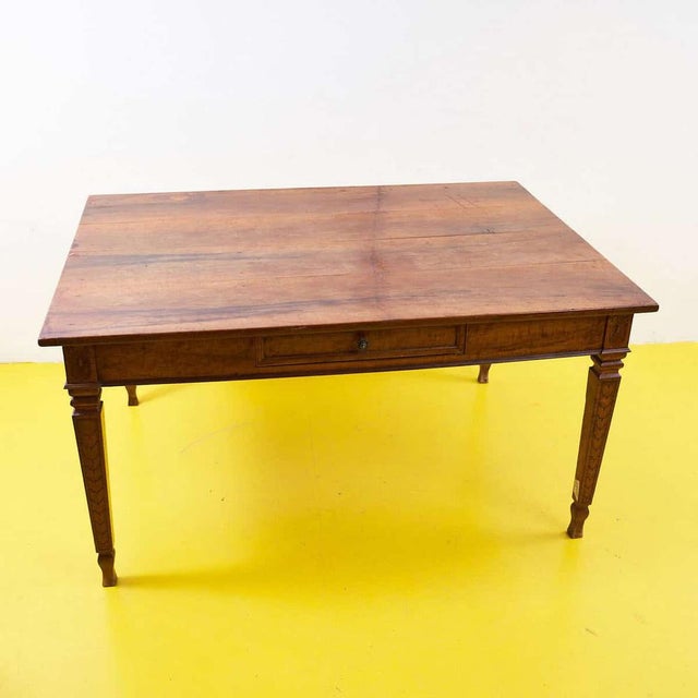 This solid wood table is a stunning example of vintage craftsmanship and design. Featuring a rustic top and simple design,...