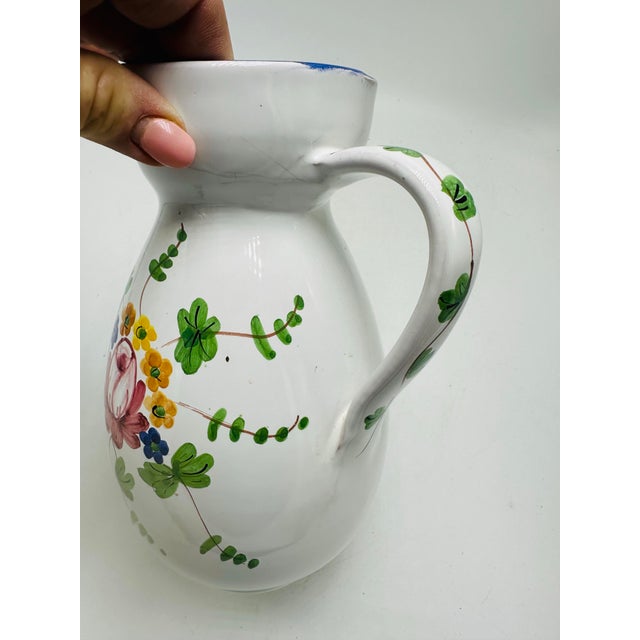 This is a hand-painted Italian ceramic pitcher marked “The Ivy – Italy” on the base. It features a white glazed body with...