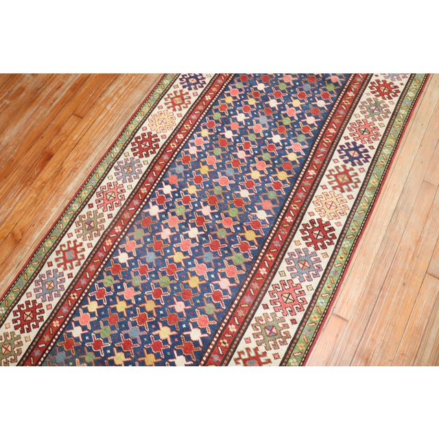 An early 20th century high decorative Caucasian Kuba runner with a colorful repetitive design on a navy color field...