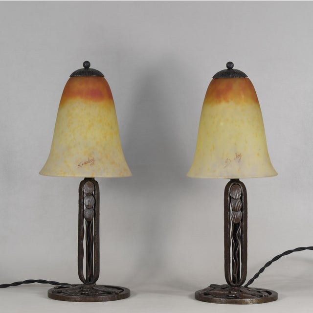 Darboy A pair of 1925-30 French art deco lamps. Daum made coloured shades on wrought iron bases of outstanding quality...