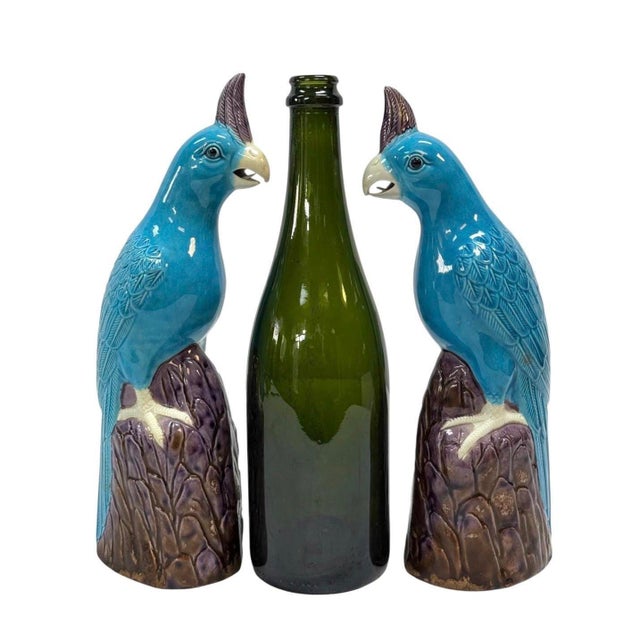 A pair of Chinese mid 20th century vintage porcelain parrots or cockatoos in vibrant turquoise blue and purple glazes....