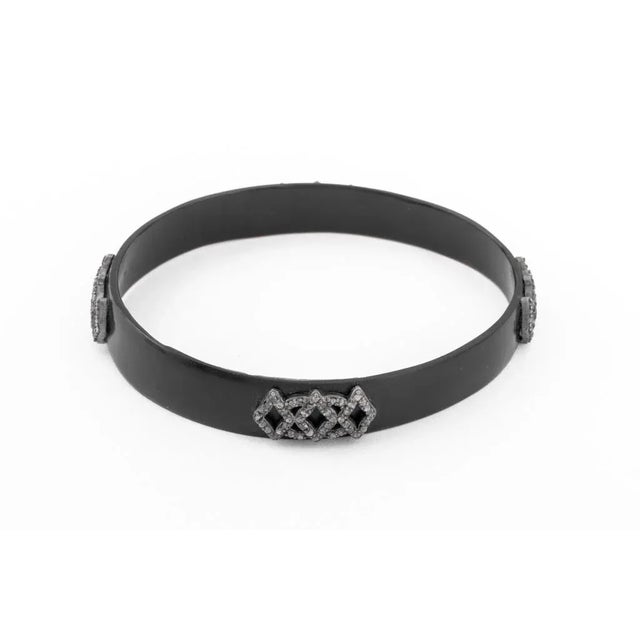 Antique composite resin mourning bangle, decorated with sterling silver motifs with table cut diamonds weighing a total of...