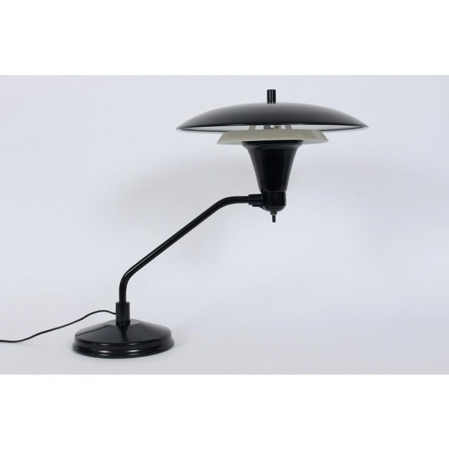 Art Specialty Co two tier black and white enamel desk lamp. Featuring a double tiered circular Shade, cantilevered arm,...