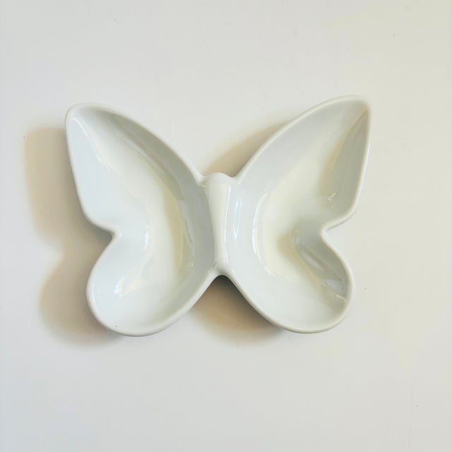 A vintage divided ceramic tray in the shape of a butterfly. Finished in a glossy white glaze. Perfect for using as a...