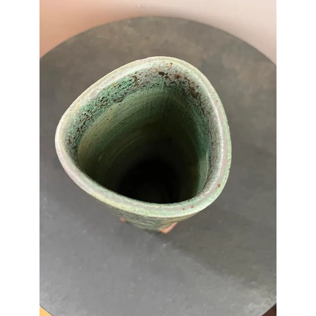 This 1960s pottery vessel blends Mid-Century Modern style with Art Nouveau influences. Its design, reminiscent of lily...