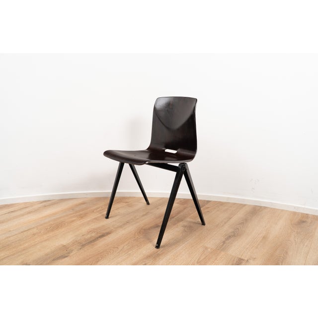 Model S22 by Galvanitas. The chair comes with a dark wooden seating and backpiece on a black coated metal frame. This...