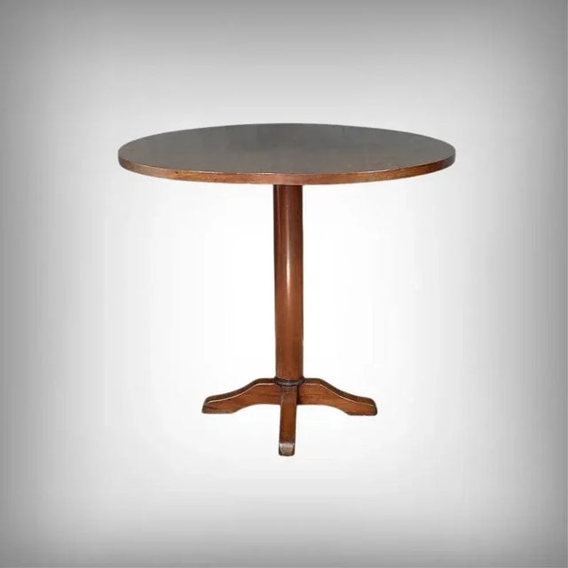 Elegant small round table crafted from mahogany, the top of which reveals the warmth and depth of its grain. It rests on a...