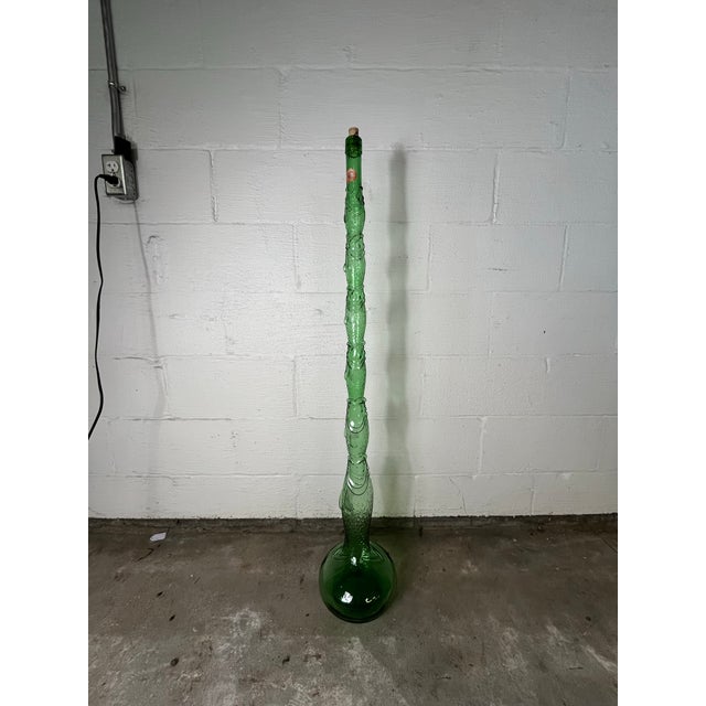 A unique vintage Chianti bottle in the shape of graduating fish. Standing at an impressive 44.2" tall, it features vibrant...