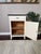 Cute early 1900s antique enamel top small cabinet or tall side table. Features a drawer on top and a spacious cabinet with...