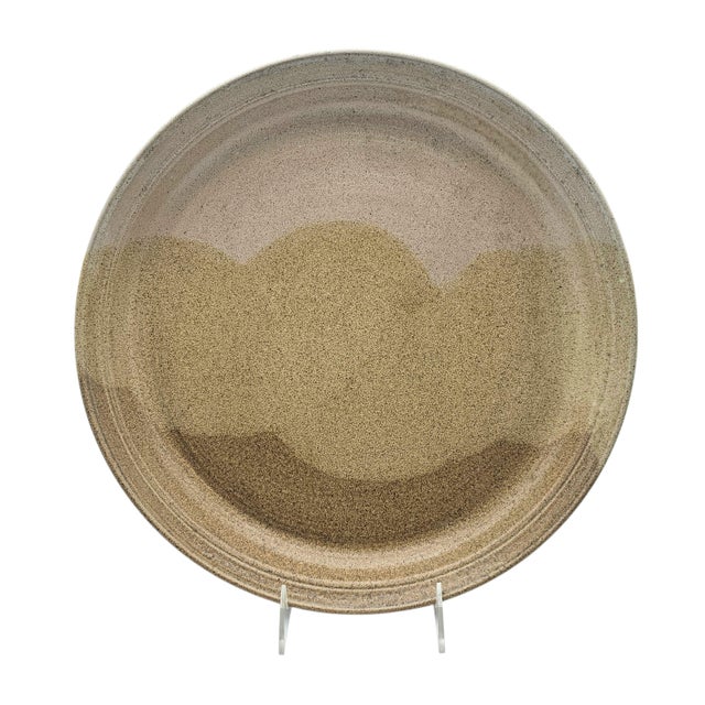 This hand-thrown stoneware plate was produced by Wild River, an American studio pottery workshop active in the late 20th...