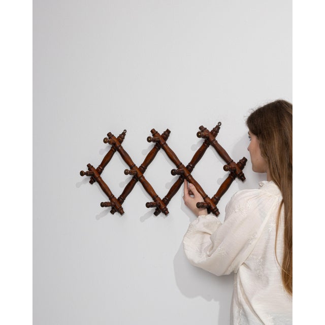 An early 20th century French coat hanger rack crafted in wood and designed in the faux bamboo style. The structure...
