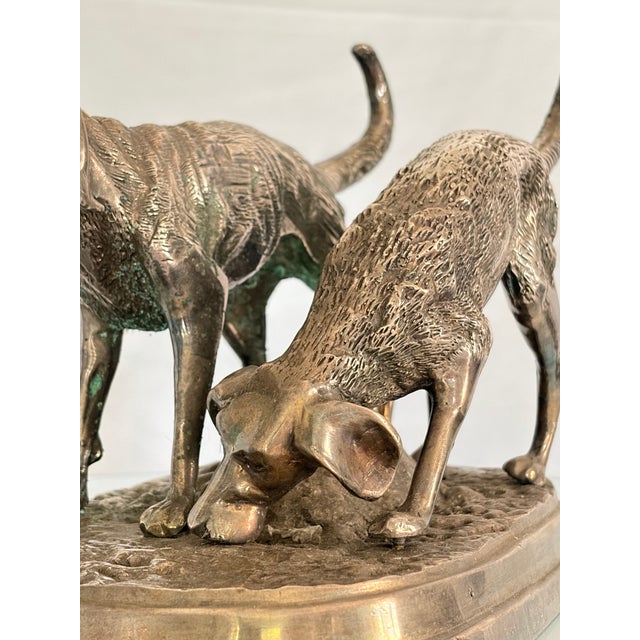 A charming French Animalier-style bronze silver leafed sculpture depicting a pair of hunting dogs in active pursuit of...