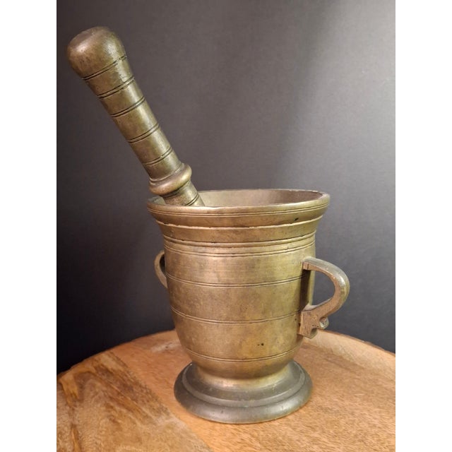 Exhibiting exceptional 18th-century scale and sculptural presence, this heavy solid cast brass mortar and pestle features...