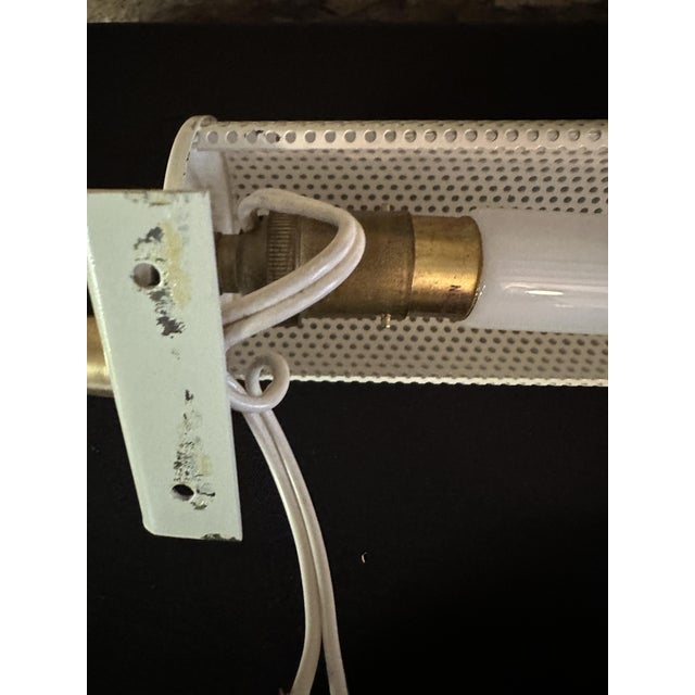 Superb pair of wall sconces by Mathieu Matégot, made in the 1950s, in perforated metal (rigitule), cream-colored. They...