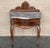 A French walnut drawer nightstands from the learly 20th century with ribbon-carved moldings and carved skirt. This petite...