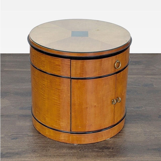 Biedermeier style round drum table with drawer and cabinet. The table has ebonized detail and brass hardware with a...