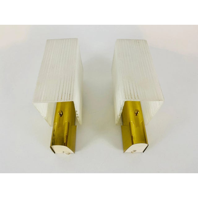 Brass and glass sconces made in Germany in the 1960s. The lamps are in a very good condition. The lights require E14 light...