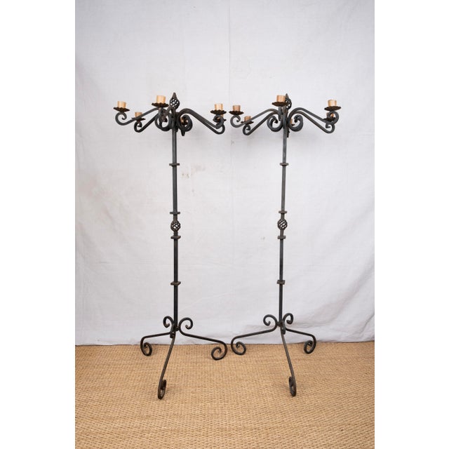 A pair of wrought iron candelabra, custom made in USA, late 20th century. Featuring six scrolled arms for pillar candles....