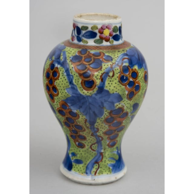 Miniature Chinese blue and white clobbered vase decorated with bunches of grapes with outline gilding, vines and foliage...
