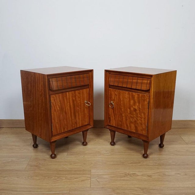 Pair of Mid-century bedside cabinets by Heal's of London. Satinwood veneered with original brass handles. Dimensions: H...