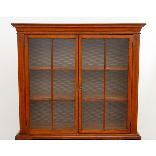 American South Cherry Jackson Press, 19th century, the top section with two glass-paneled doors opening to three shelves,...