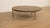 A distinctive 1970s vintage coffee table featuring a striking, round tabletop made of heavy natural stone. The surface...