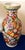 This striking 16-inch porcelain vase features a beautifully hand‑painted Famille Rose floral design in vivid shades of...