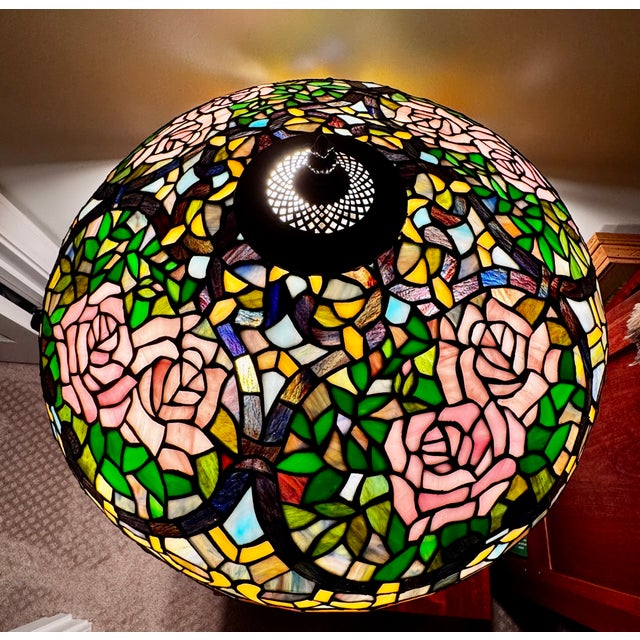 Tiffany style stained rose petal three (3) bulb stained glass table lamp with brass base. Lamp shade has pink and pearl...