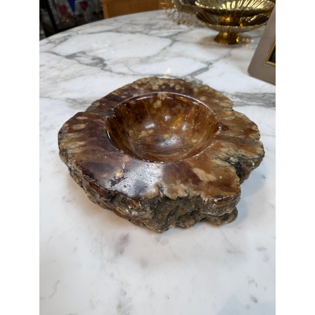 Striking solid marble ashtray featuring rich brown, cream, and amber-toned veining. The smoothly polished center contrasts...