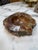 Striking solid marble ashtray featuring rich brown, cream, and amber-toned veining. The smoothly polished center contrasts...