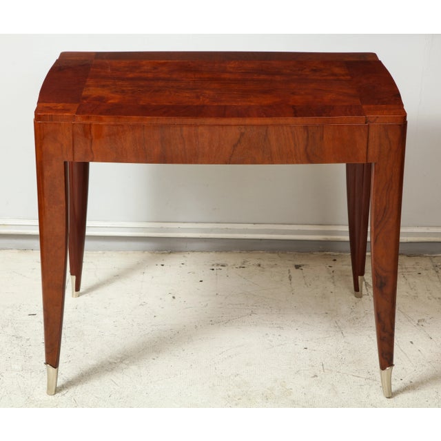 Bespoke table in the manner of Jules Leleu. Table is crafted in walnut and features four sabor legs ending in nickel...