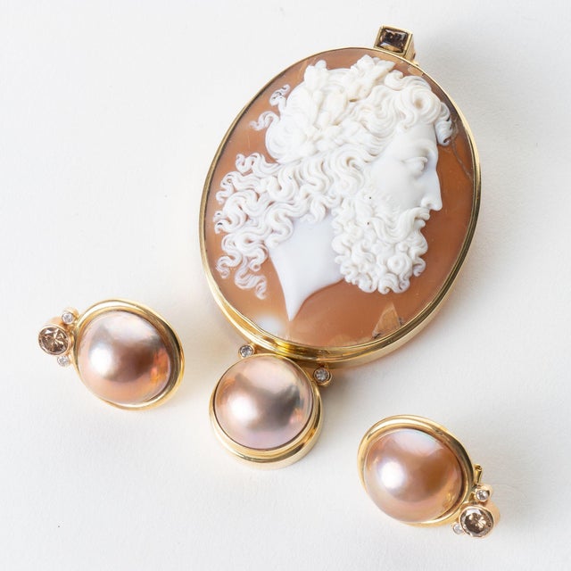 Exquisitely carved oval shell cameo profile pendant of Zeus remounted in a custom 18K gold bezel with enhancements of mabé...