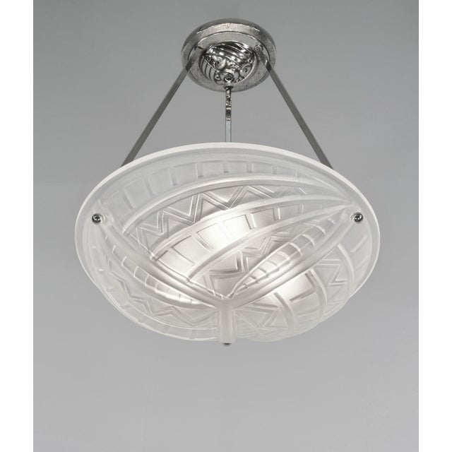 NOVERDY A French 1930 art deco pendant light in nickel plated solid brass holding a bowl in clear frosted molded-pressed...
