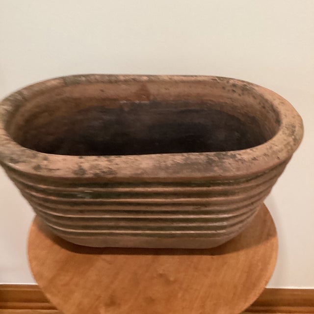 The Vintage Large Rustic Oval Terracotta Wide-Ribbed Oval Planter is a unique and charming addition to any room. With its...