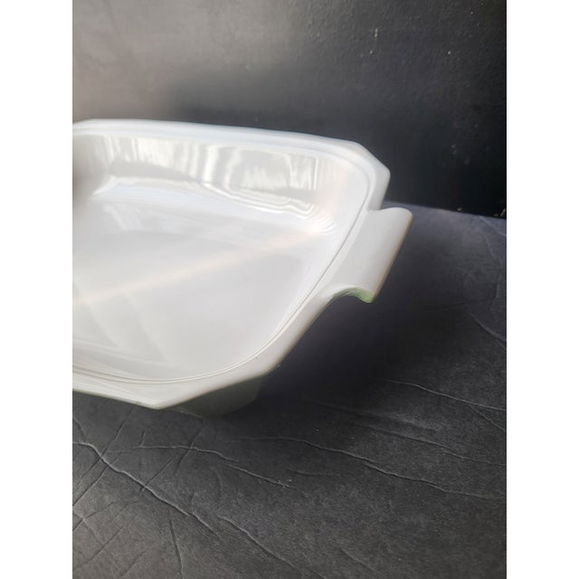This deep, heavyweight casserole serving dish can move directly from oven to table. In excellent condition. Stamped on the...