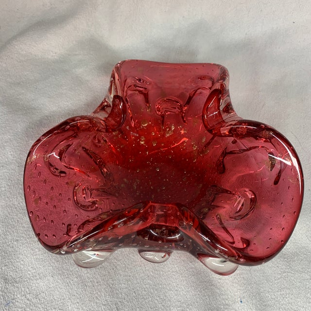 This vintage mid-century Italian hand-blown Murano raspberry red art glass ashtray and trinket bowl features distinctive...