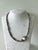 This specific piece is known for its handcrafted aesthetic, featuring a mix of irregular silver-plated beads and a central...