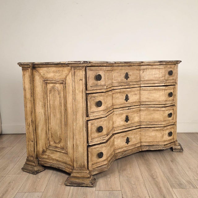 A large scale Baroque painted chest of drawers made in Denmark circa 1750 in the Italian style. This commode is a bold...