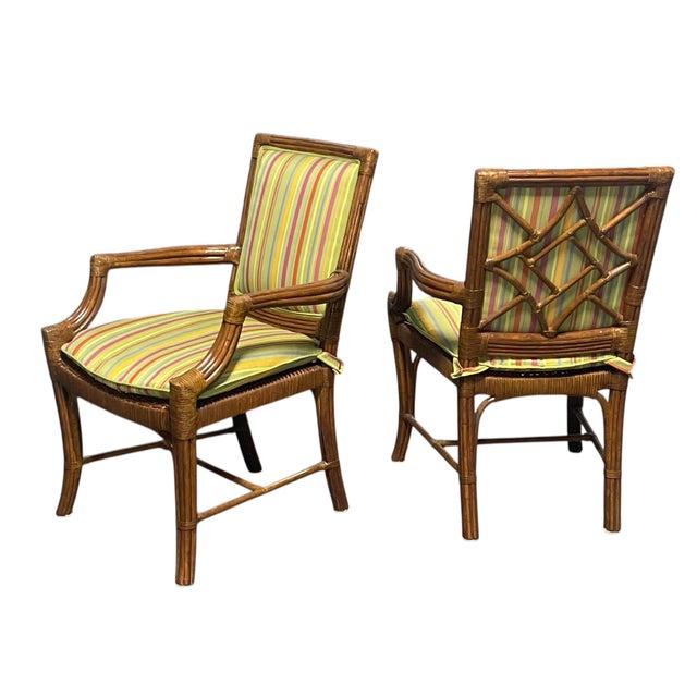 A set of six rattan arm chairs by Lane Venture Excursions. These chairs feature padded backs and removable seat cushions....