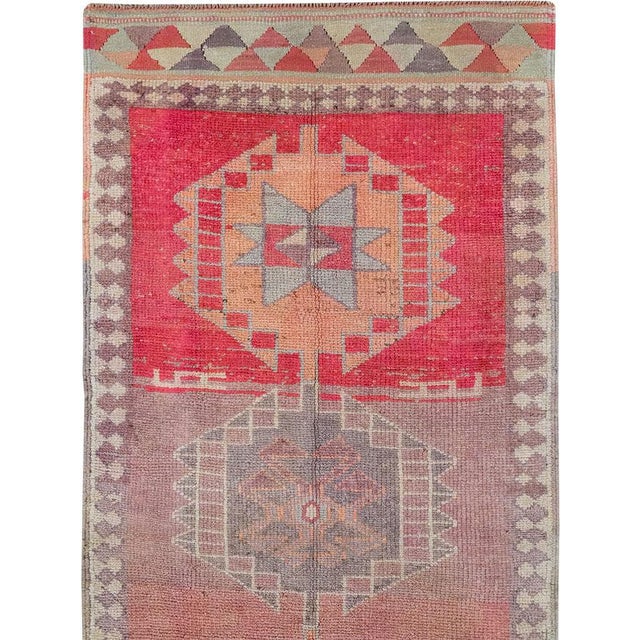 This mid-20th-century Turkish Anatolian long runner presents a rhythmic procession of ten linked geometric medallions...