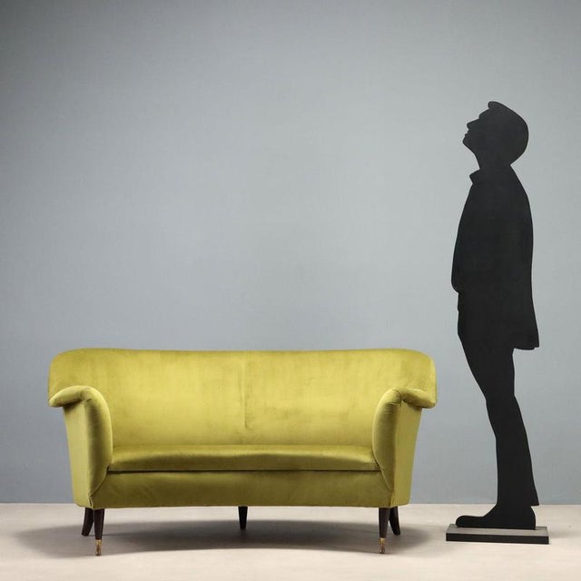 A 1950s Italian-made bean-shaped sofa, characterized by the soft, enveloping lines typical of the era's design. The frame...