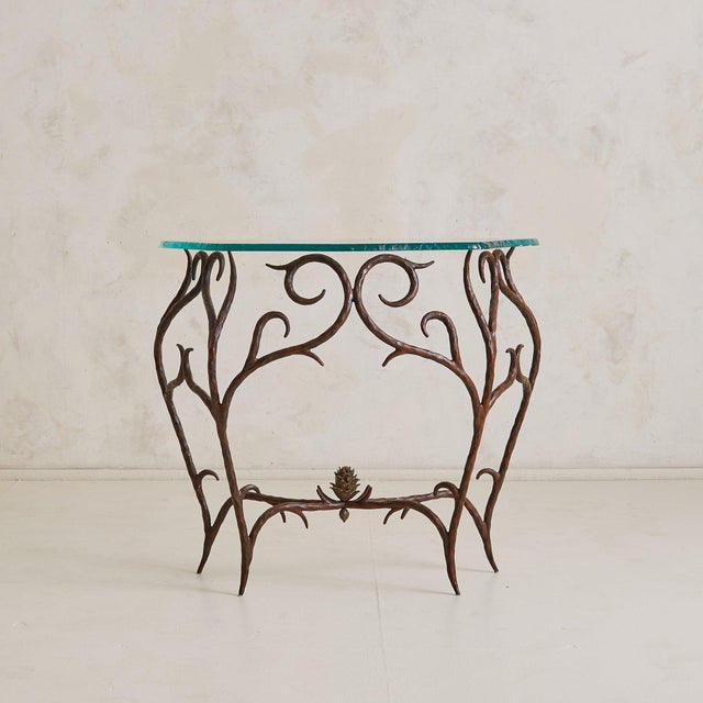 A lyrical French console table from the 1970s, crafted in hand-forged bronze with a chiseled glass top. The frame unfolds...