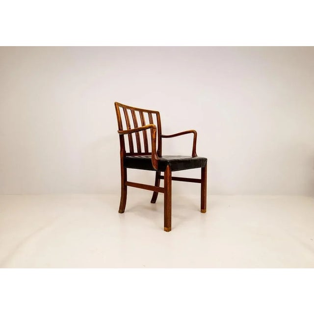 This partial heavy patinated armchair was designed and created 1942 by Ole Wanscher and manufactured at Fritz Hansen in...