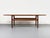 Iconic teak coffee table with an additional shelf beneath the main tabletop. Its distinctive features include the organic...