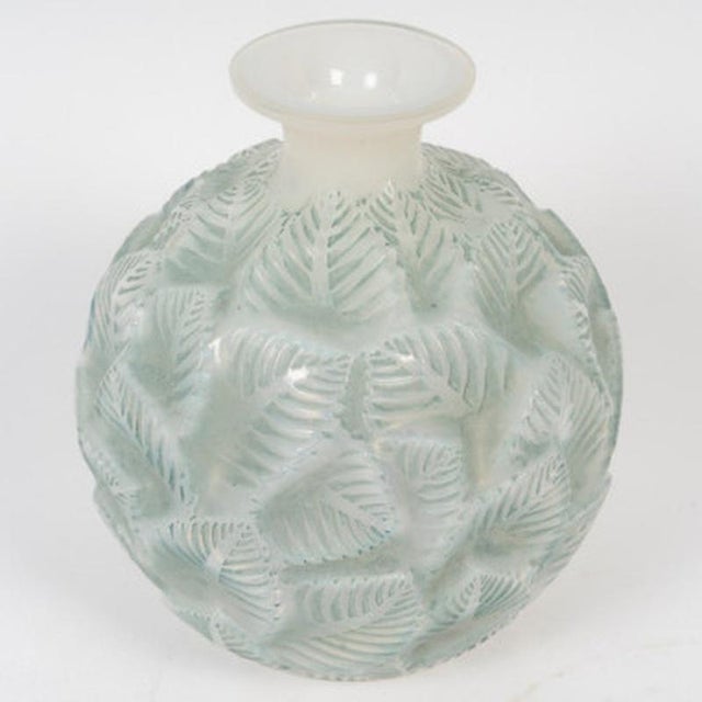 “Ormeaux” vase in pressed molded opalescent glass, enhanced with a blue-green patina. Model designed by René Lalique in...