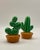 A pair of vintage salt & pepper shakers, one in the shape of a prickly pear and the other in the shape of a saguaro cactus.
